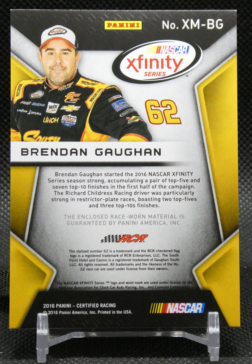 NASCAR Xfinity Series trading card featuring Brendan Gaughan #62 in a yellow-and-black racing suit with bio text on the card.