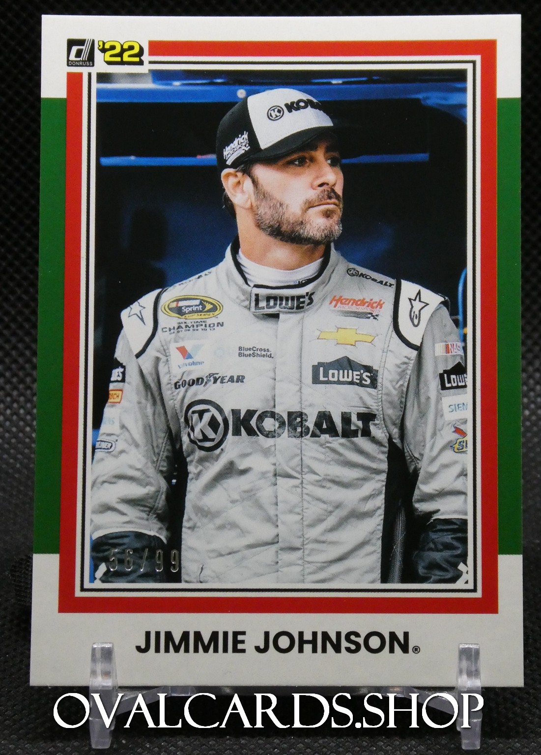 Trading card shows NASCAR driver Jimmie Johnson in a gray Kobalt racing suit with sponsor logos (Lowe's, Goodyear) and a black-and-white cap, looking to the right.