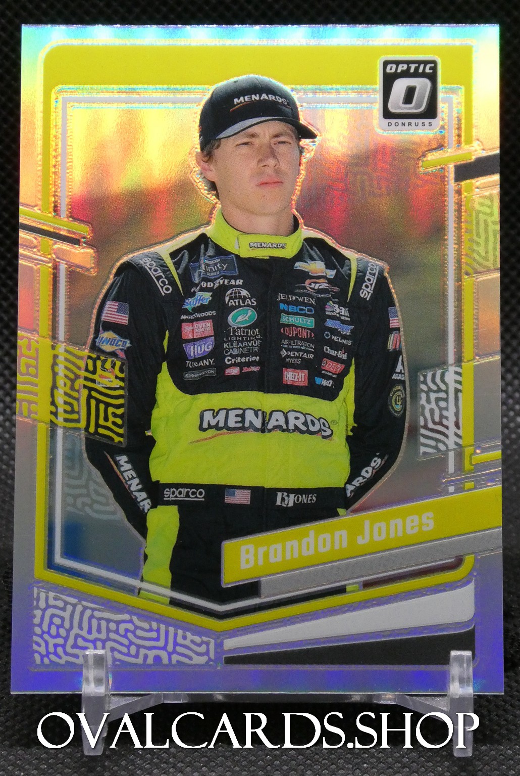 Holographic NASCAR trading card of Brandon Jones in a neon yellow and black Menards racing suit with sponsor logos, name displayed at bottom.