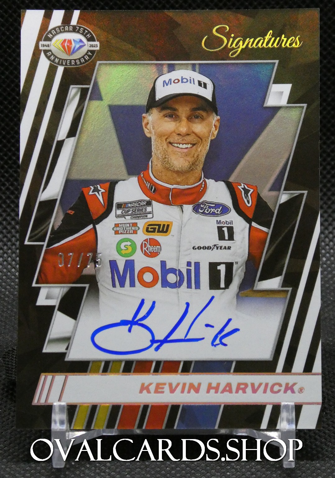 Autographed NASCAR trading card of Kevin Harvick from the Signatures series, showing him in a white Mobil 1 racing suit and cap with his blue signature across the bottom.