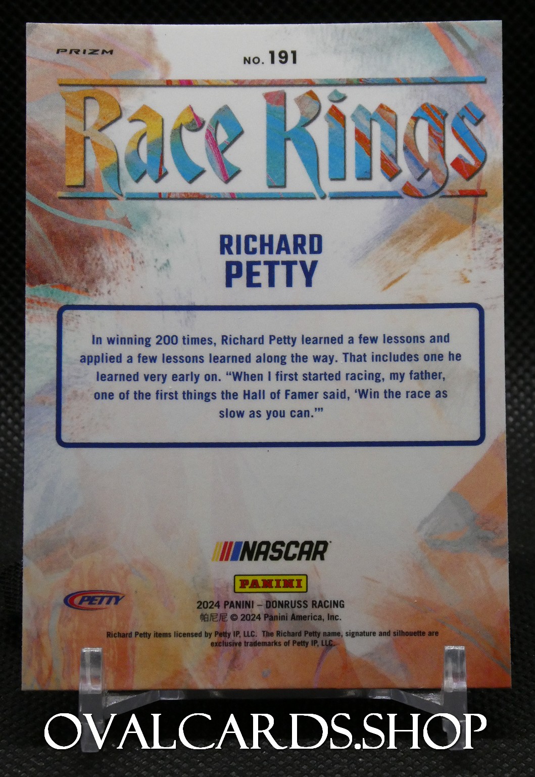 Trading card back: 'Race Kings' header, 'Richard Petty' name, Nascar/Panini branding, colorful abstract background and a blue-bordered text box with two-paragraph story.