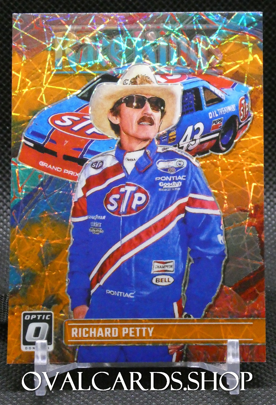 Richard Petty in a blue STP racing suit with a holographic orange background and the name 'RICHARD PETTY' on the card edge.