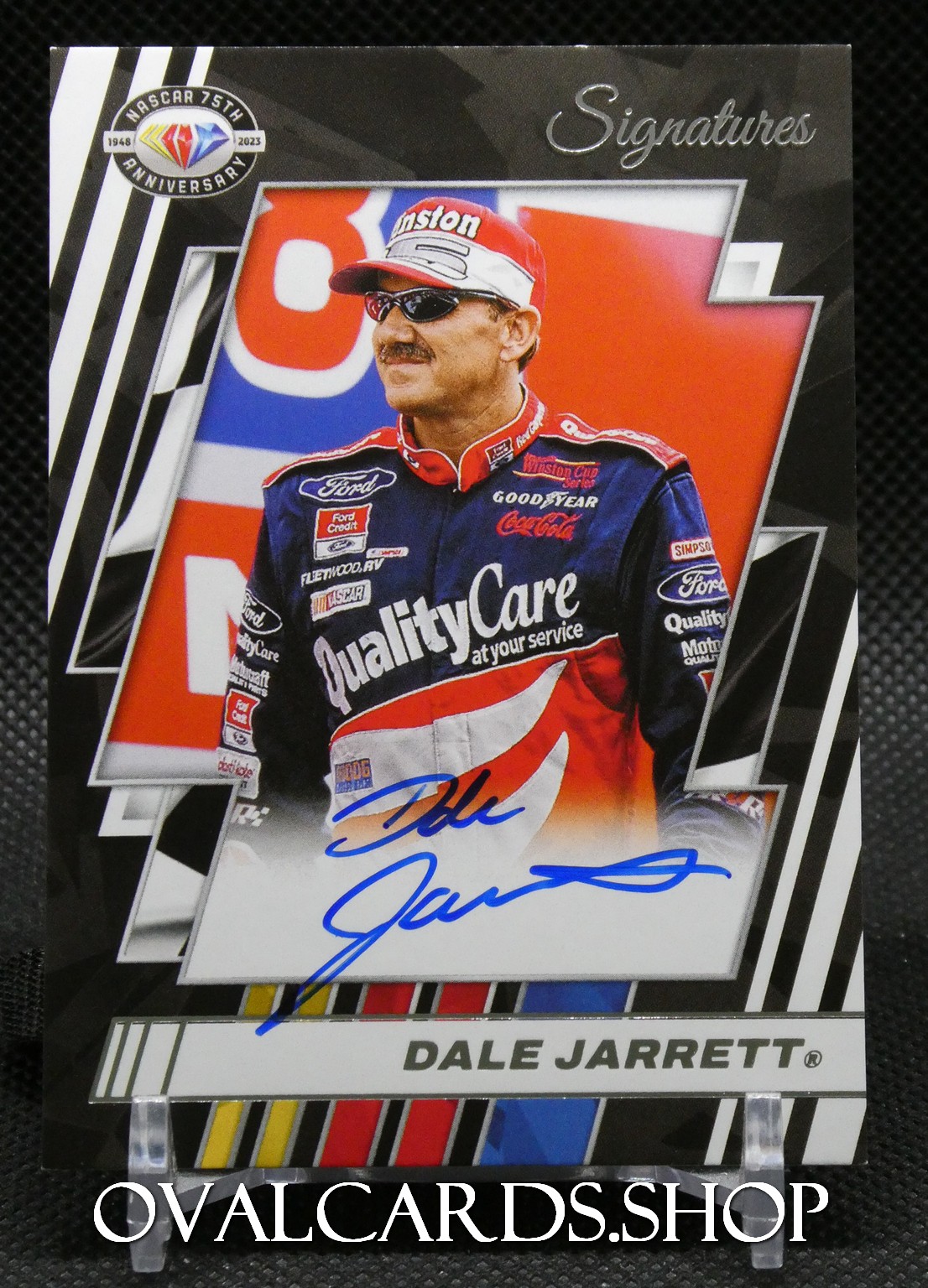 Autographed Dale Jarrett NASCAR trading card in a layered black-and-white design with Jarrett in a red-blue racing suit and blue signature across the lower panel