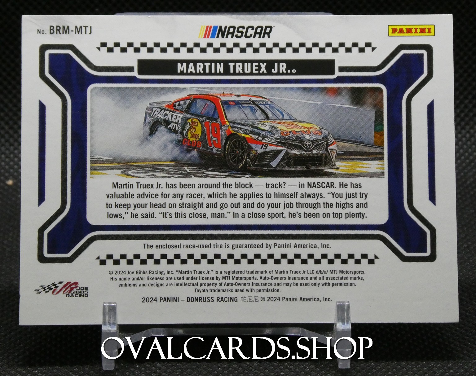NASCAR trading card back featuring Martin Truex Jr.’s red-and-black race car (#19) on a track, with descriptive text and Panini logo.