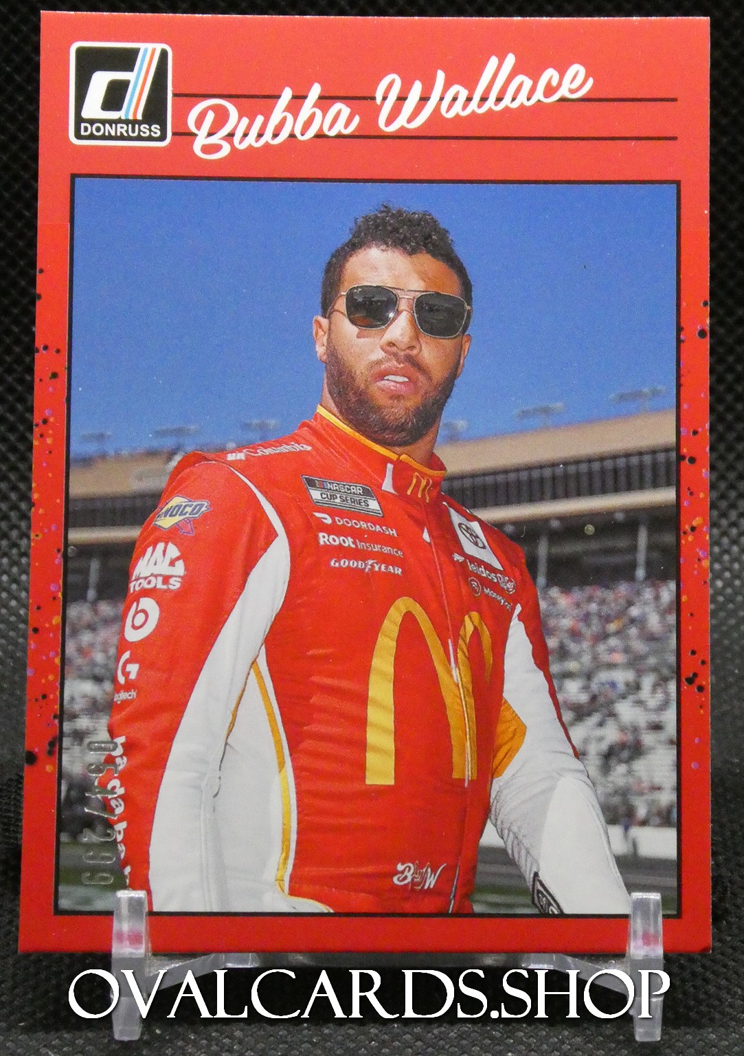 Donruss NASCAR trading card featuring a driver in a red McDonald’s racing suit wearing sunglasses on a race track.