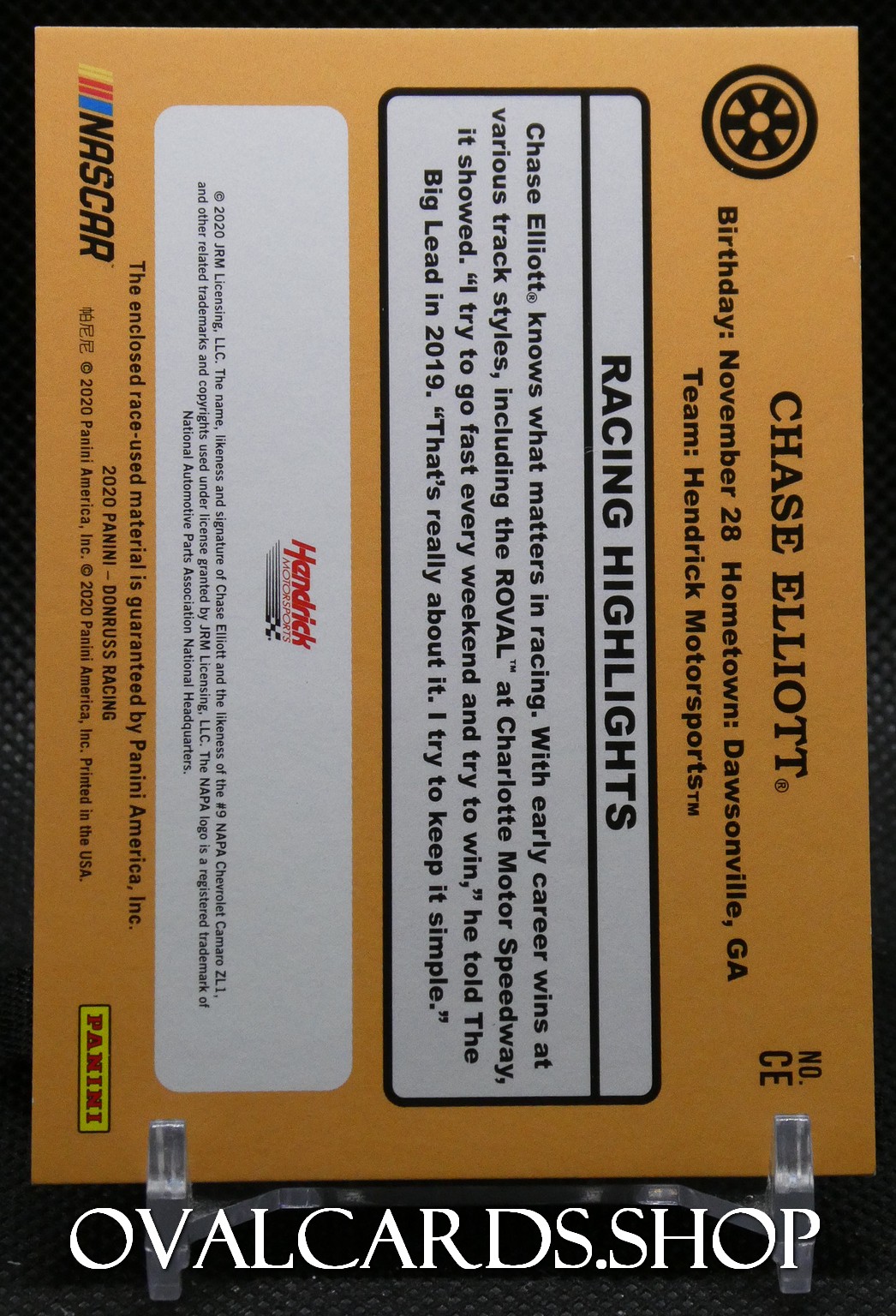 Orange NASCAR Chase Elliott die-cast car packaging shown from side, labeled Racing Highlights with brand logos and text blocks.