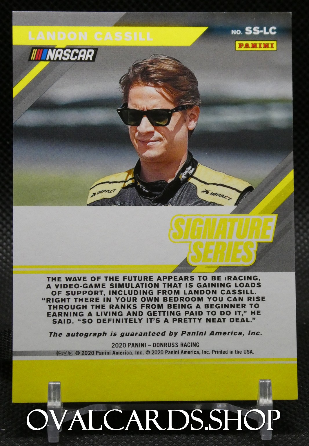 Landon Cassill NASCAR Panini card from the Signature Series showing Cassill in a yellow-black racing suit wearing sunglasses, with his name at the top.