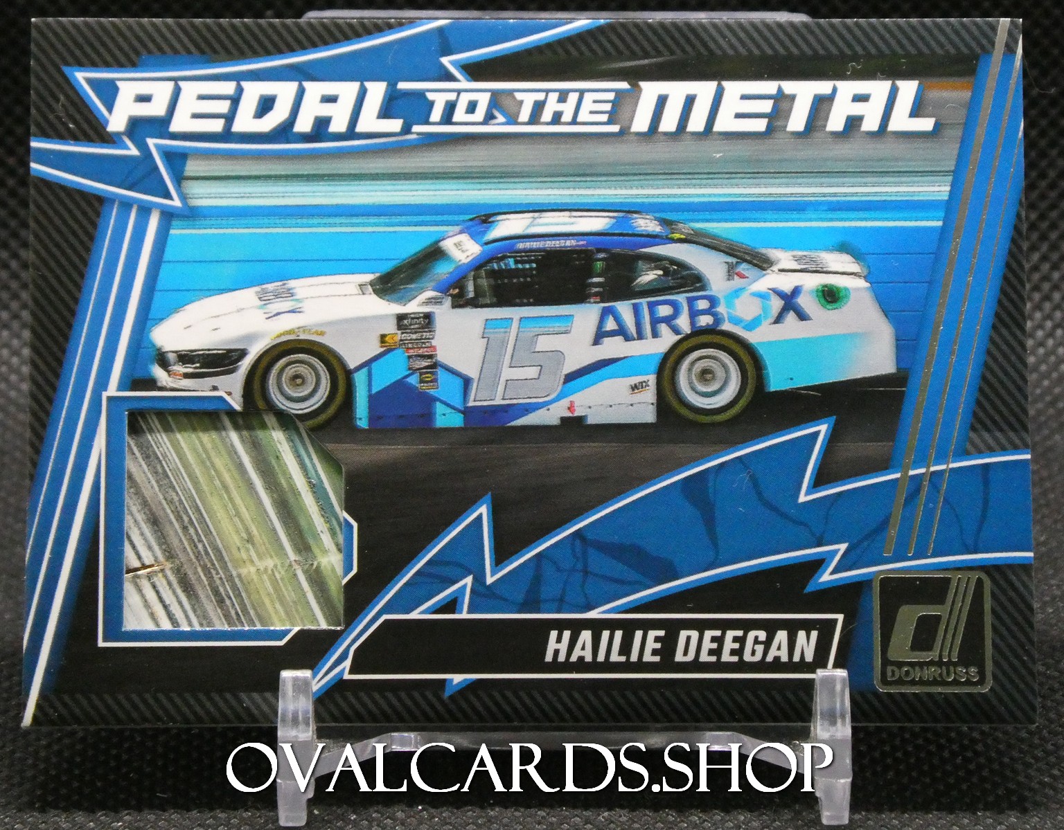Cardboard display featuring a white-blue racing car with number 15 and 'AIRBOX' livery, under the 'Pedal to the Metal' branding, Hailee Deegan name at bottom, Donruss logo present.