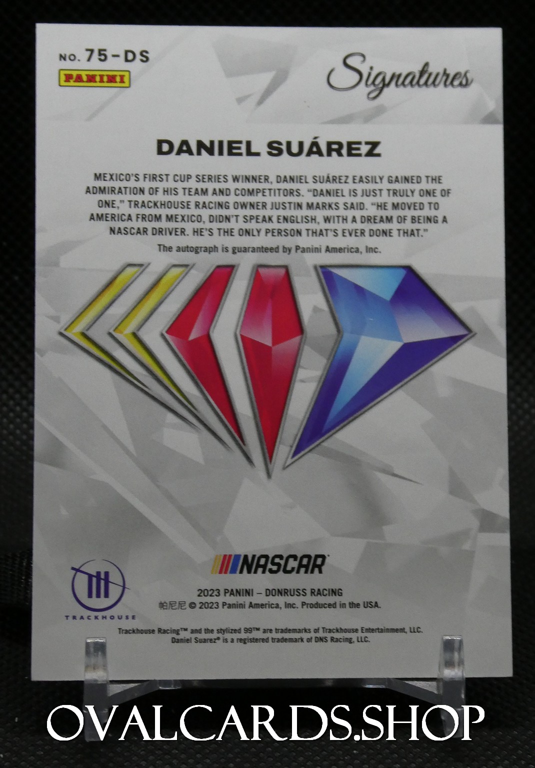 Poster with Daniel Suárez autograph from Panini Signatures, featuring colorful diamond logos and NASCAR Trackhouse branding.