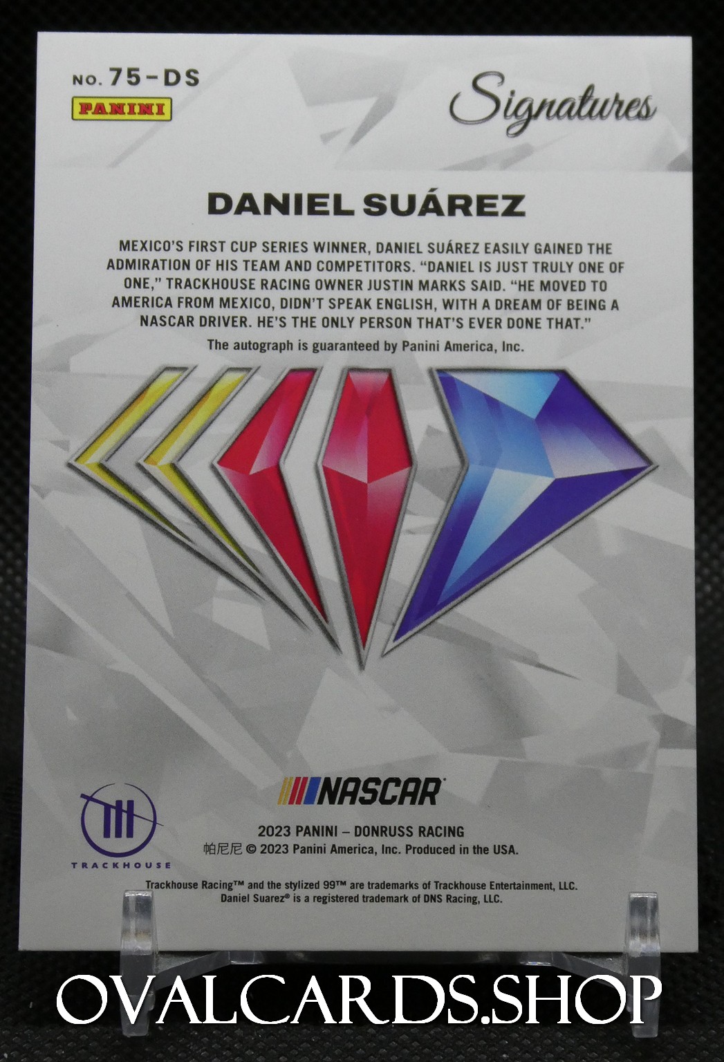 Panini Signatures card featuring Daniel Suárez with colored diamond graphics and Nascar logo at bottom, and Trackhouse branding.